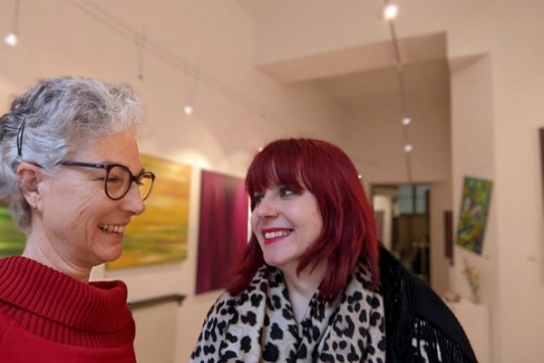 2 miteinander sprechende Frauen in einer Galerie