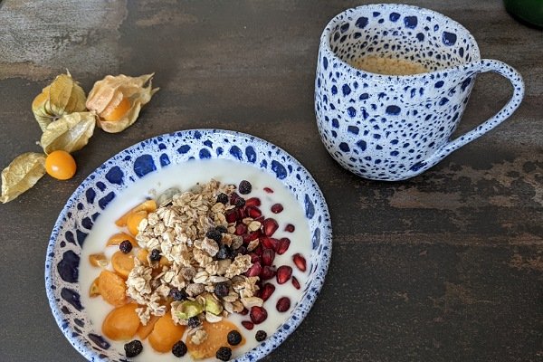 Schale mit Müsli, Joghurt und Obst; Kaffee