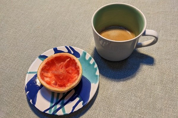 halbe Grapefruit und eine Tasse Kaffee