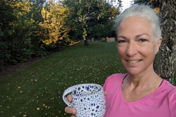 Frau mit Kaffeetasse im Garten